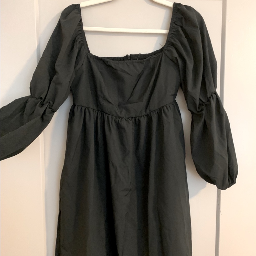Simple long sleeve black dress with cinched bands at the elbows.